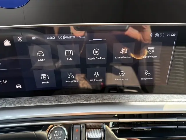 Écran tactile central du tableau de bord du Peugeot 5008 bleu, affichant les menus Apple CarPlay et climatisation.