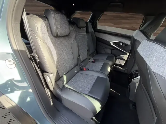 Vue intérieure côté gauche sur la banquette arrière en tissu et cuir gris du Peugeot 5008 bleu 2025.