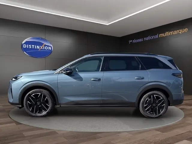 Vue latérale droite du Peugeot 5008 bleu 2025 en version hybride, avec jantes noires et toit noir contrastant.