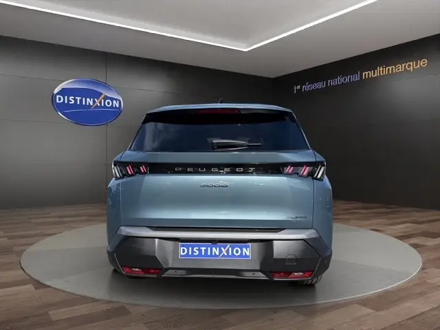 Vue arrière du Peugeot 5008 bleu 2025 dans un showroom, avec feux LED et logo distinctif bien visibles.