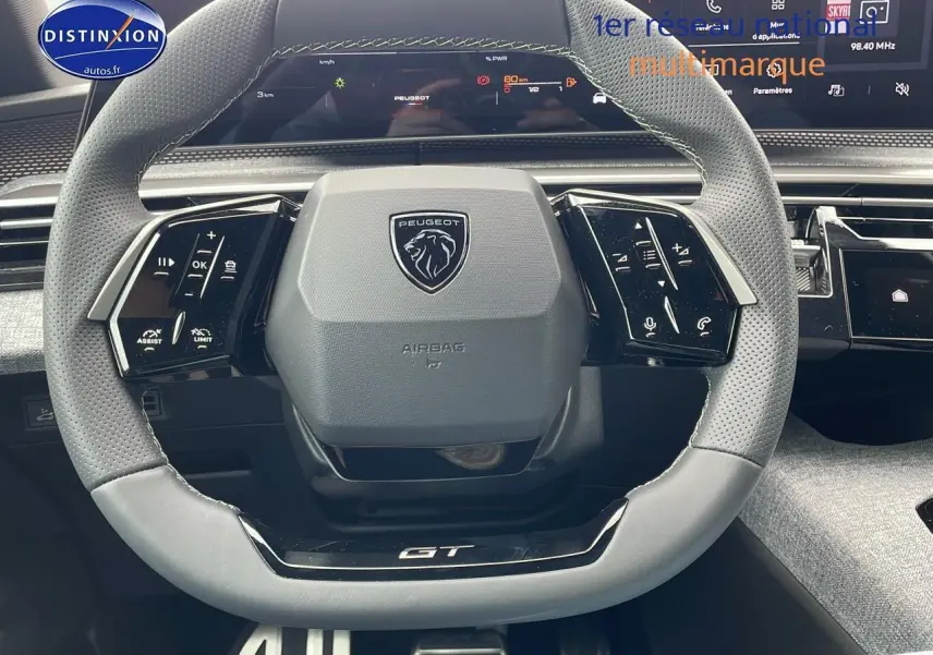 Volant cuir perforé avec logo Peugeot et inscription GT, tableau de bord digital et écran tactile du Peugeot 3008 Hybrid 145 GT.