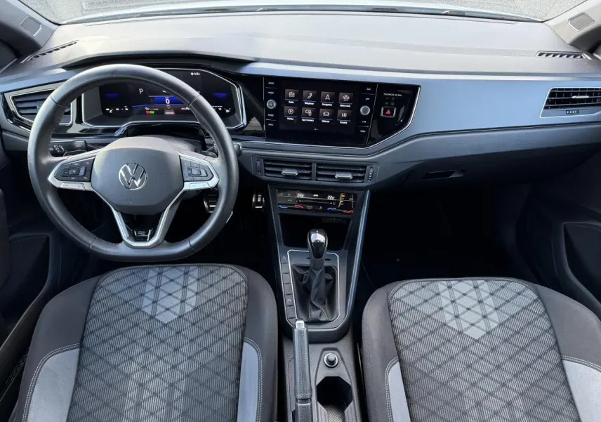 Intérieur du Volkswagen Polo 2025 vu de face, volant cuir multifonction et écran tactile central noir.