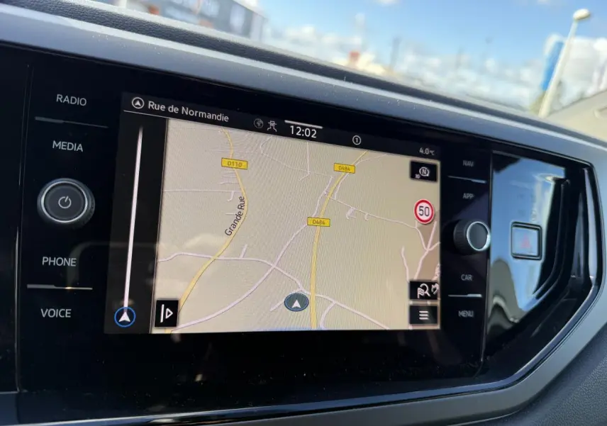 Écran tactile du système de navigation Discover Media dans l'habitacle du Volkswagen Polo blanc, vue de face.