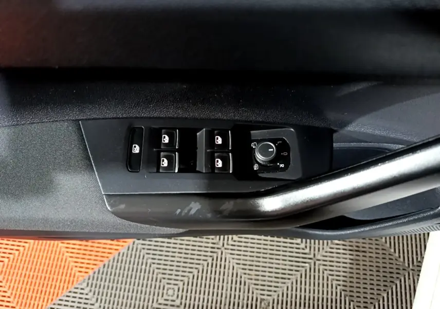 Gros plan sur la commande des vitres et rétroviseurs côté conducteur du Volkswagen Taigo blanc, version R-Line 2022.