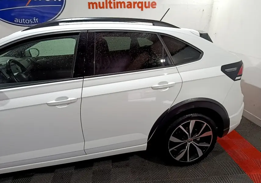 Vue latérale droite d'un Volkswagen Taigo blanc 2022 avec jantes alliage et rails de toit noirs.