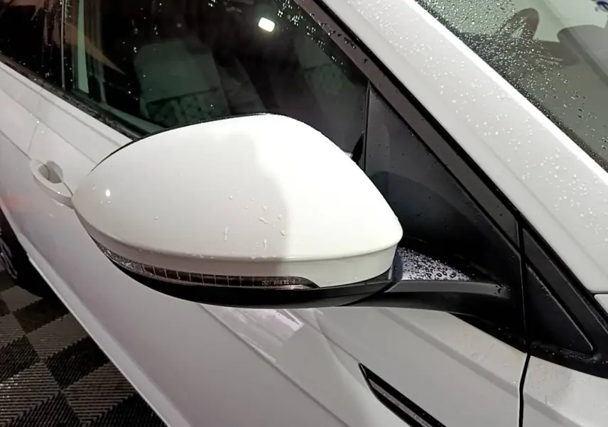 Rétroviseur côté gauche blanc de Volkswagen Taigo 1.0 TSI 110 DSG R-Line 2022 avec carrosserie blanche humide.