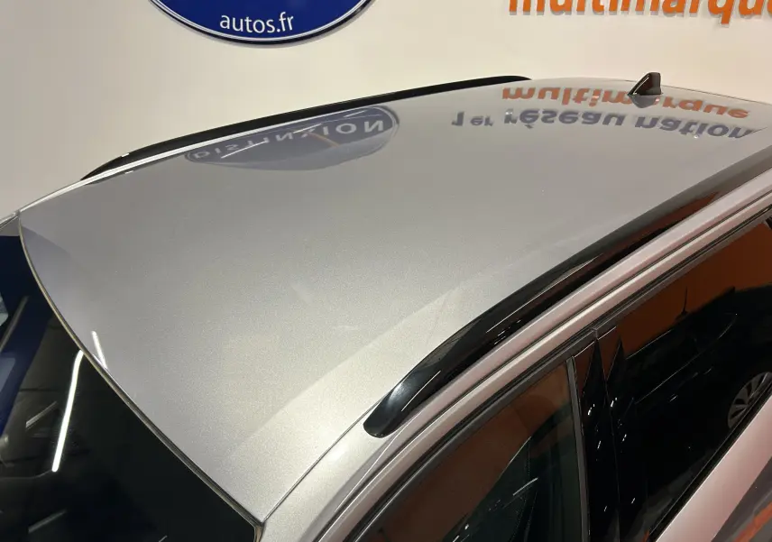 Vue en plongée du toit gris Artense métallisé du Peugeot 5008 III Hybrid avec barres de toit noires.