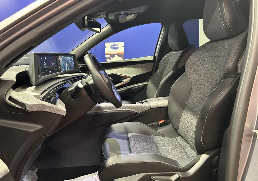 Vue intérieure côté conducteur du Peugeot 5008 gris Artense, avec sièges bi-matière et tableau de bord numérique.