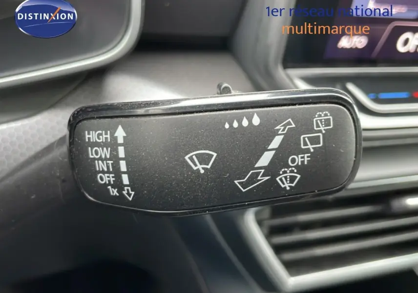 Gros plan sur la commande d’essuie-glace du tableau de bord intérieur d’une SEAT Leon bleu Fjord 2025.