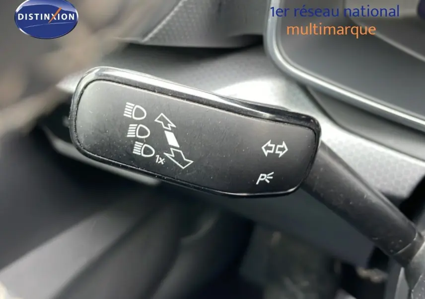 Gros plan sur le commodo de clignotants et feux d’un SEAT Leon 2025, intérieur gris noir.