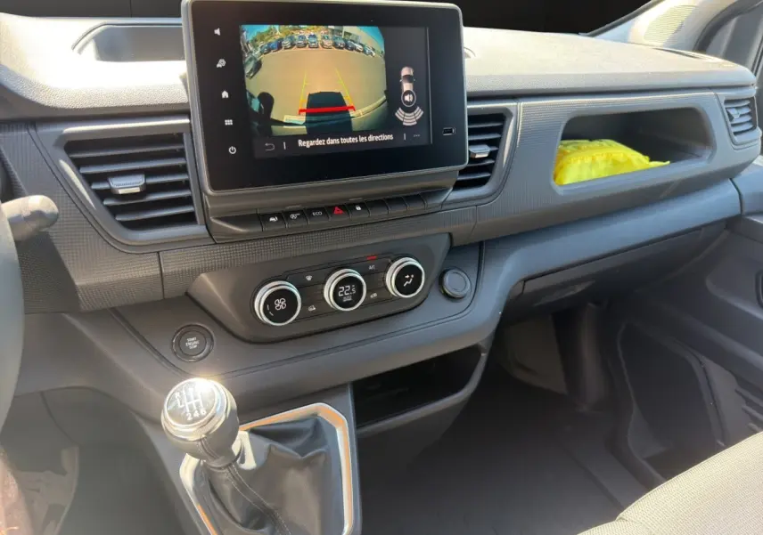 Vue intérieure côté passager du tableau de bord gris foncé du Renault Trafic Fourgon avec écran tactile et levier de vitesse manuel.