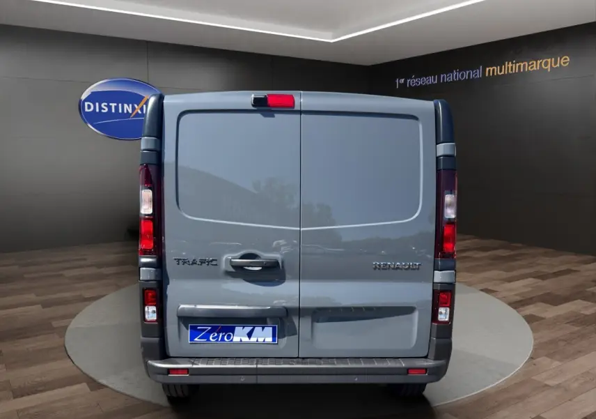 Vue arrière du Renault Trafic Fourgon gris foncé, portes battantes fermées avec logo et feux verticaux rouges.
