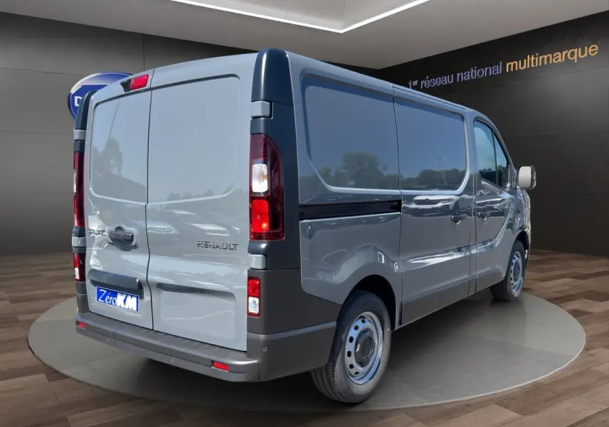 Vue 3/4 arrière droite du Renault Trafic Fourgon gris foncé avec portes arrière pleines et jantes tôles simples.