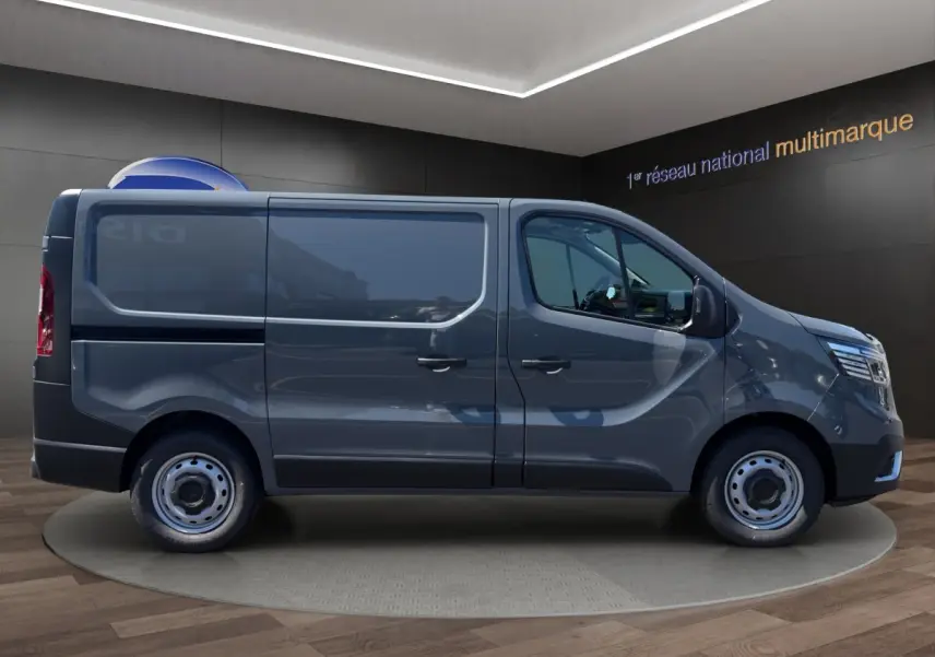 Vue de profil côté gauche d'un Renault Trafic Fourgon gris foncé avec jantes acier et vitres teintées.