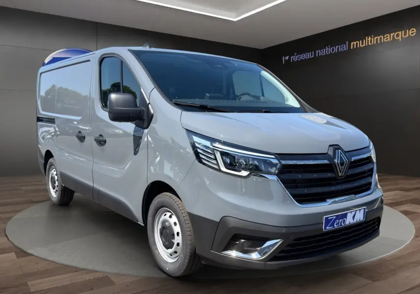 Renault Trafic Fourgon gris foncé en 3/4 avant droit, avec phares LED et jantes acier visibles.