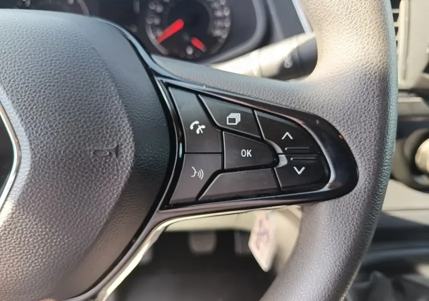 Gros plan sur le volant multifonctions noir du Renault Trafic Fourgon 2023, montrant les commandes de navigation et téléphone.