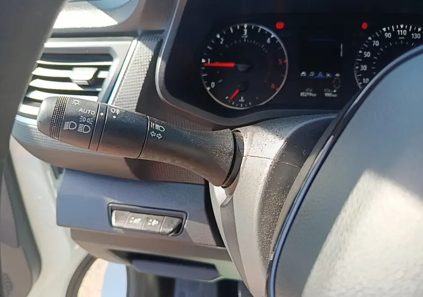 Vue intérieure rapprochée du tableau de bord et du commodo d’éclairage du Renault Trafic Fourgon blanc 2023.