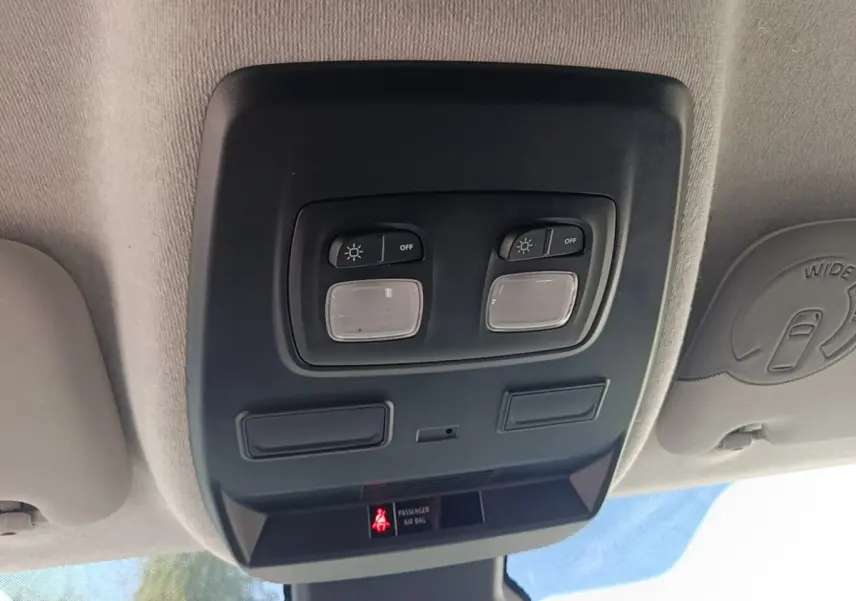 Plafonnier intérieur avec commandes d’éclairage et témoin airbag passager, vue du poste de conduite Renault Trafic Fourgon blanc.