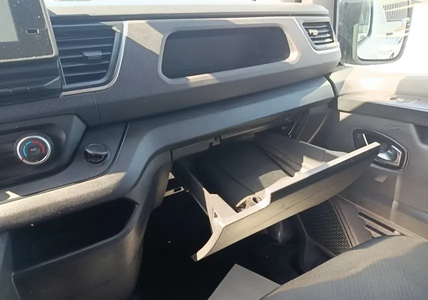 Vue intérieure côté passager du Renault Trafic Fourgon 2023, boîte à gants ouverte et tableau de bord noir.