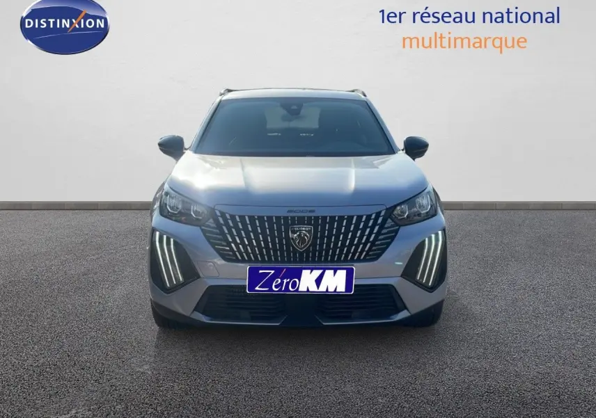 Vue frontale d'un Peugeot 2008 Hybrid gris Artense métal avec feux LED distinctifs allumés sur un sol gris.