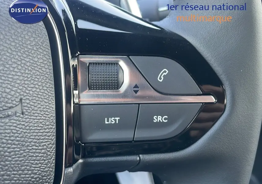 Gros plan sur les commandes du volant du Peugeot 2008 gris Artense, mettant en valeur les boutons LIST et SRC.