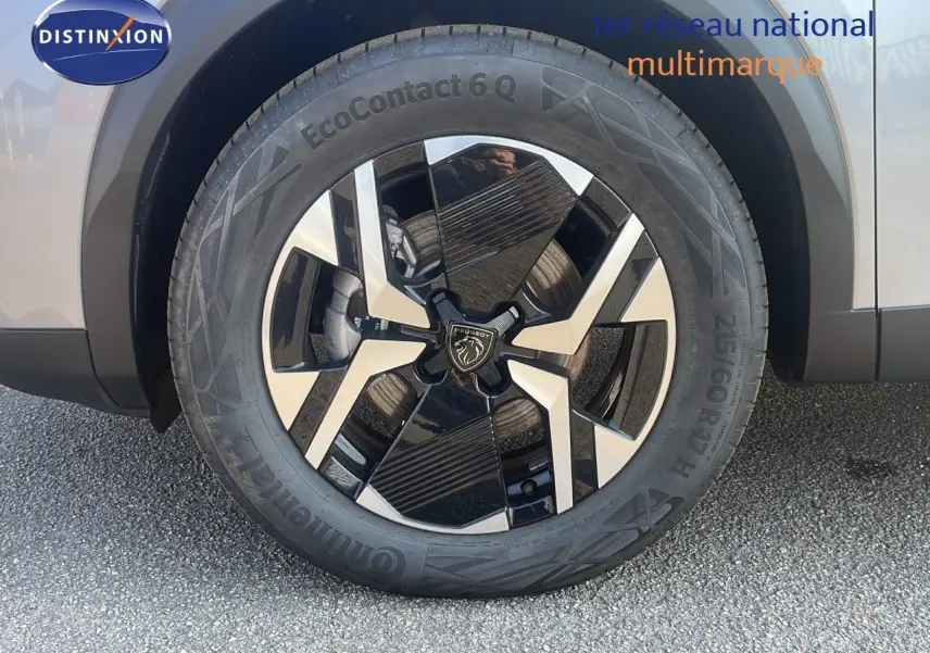 Gros plan sur la roue avant droite du Peugeot 2008 Hybrid gris Artense métal avec jante alliage bicolore moderne.