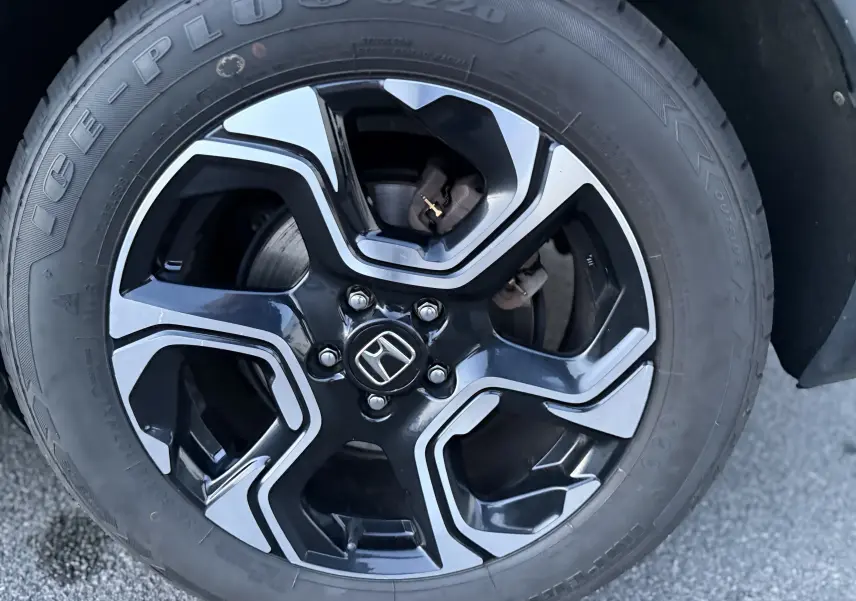 Gros plan sur la jante noire et argentée du Honda CR-V Hybrid 2019, mettant en valeur le logo Honda central.