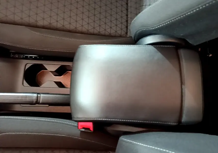 Vue intérieure rapprochée du coffre central en cuir noir entre les sièges avant du Volkswagen T-Cross gris foncé.