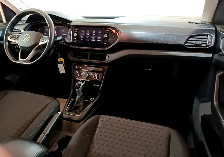 Intérieur du Volkswagen T-Cross 2023, vue de face côté conducteur, volant cuir multifonctions et écran tactile central.