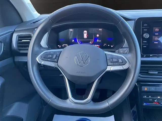 Vue frontale du volant cuir noir du Volkswagen T-Cross 2025 avec tableau de bord digital et écran tactile central.