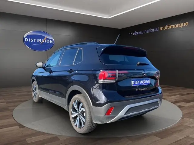 Vue 3/4 arrière droite d'un Volkswagen T-Cross noir nacré 2025 avec jantes alliage et vitres surteintées.