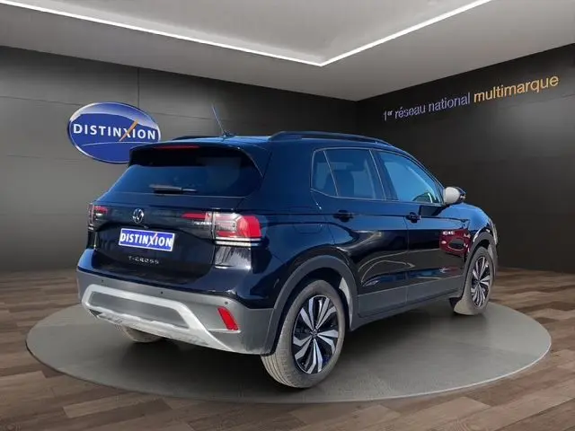 Volkswagen T-Cross noir en 3/4 arrière droit, avec jantes alliage et feux LED, sur plateforme en showroom.