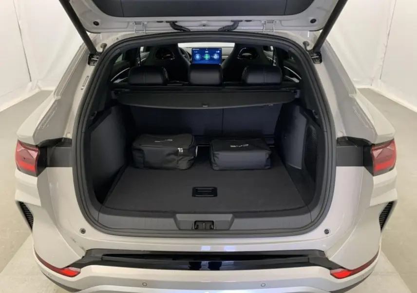 Vue arrière du coffre ouvert du BYD SEAL U 2025 en blanc Boundless Cloud, avec deux sacs noirs posés à l'intérieur.