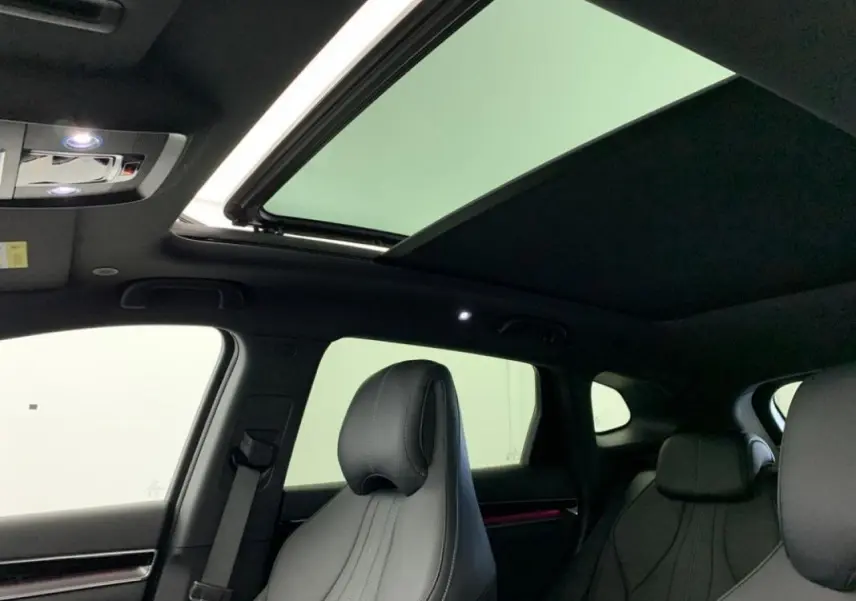 Vue intérieure montrant le toit ouvrant panoramique et les sièges avant en similicuir noir du BYD SEAL U 2025.