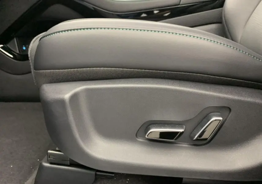 Gros plan sur les commandes de réglage électrique du siège conducteur en similicuir noir avec surpiqûres vertes du BYD SEAL U 2025.