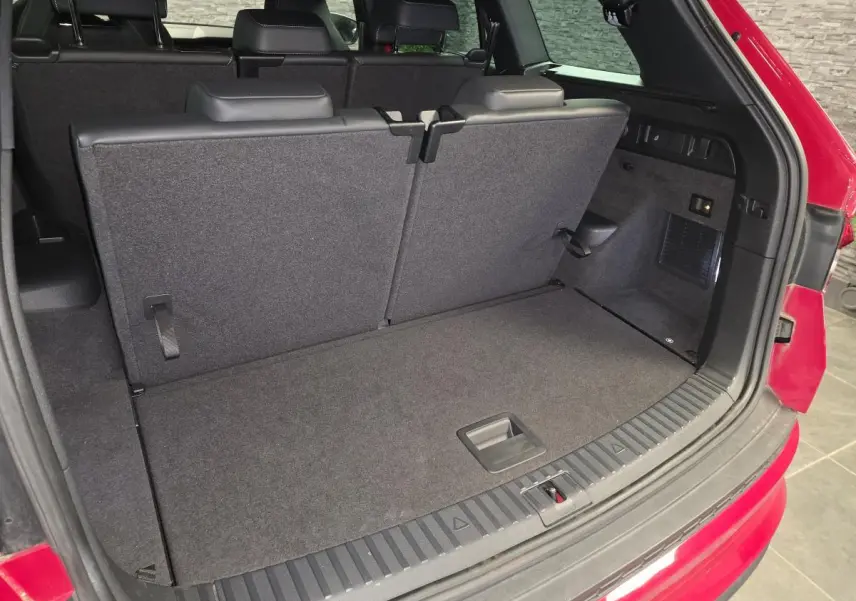 Coffre ouvert vu de l'arrière d'un Skoda Kodiaq rouge avec banquette arrière relevée et intérieur noir.