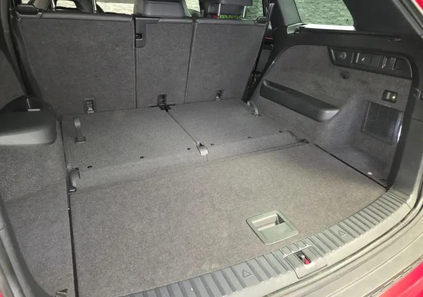 Coffre ouvert du Skoda Kodiaq rouge, vue arrière avec banquette arrière partiellement rabattue et espace de chargement plat.