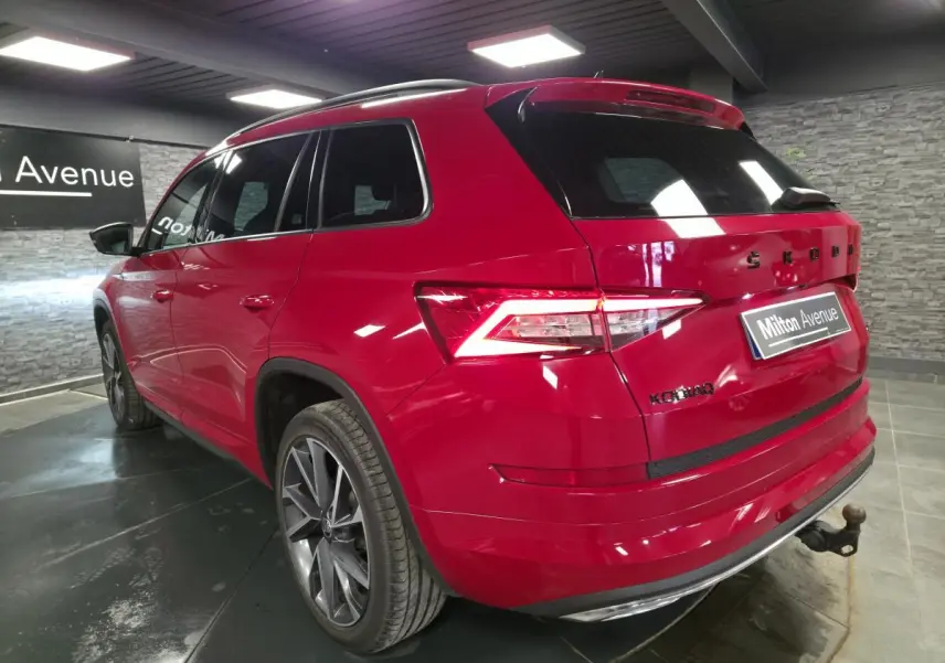 Vue 3/4 arrière droite du Skoda Kodiaq rouge 2021 avec jantes alliage 20 pouces et crochet d'attelage escamotable.