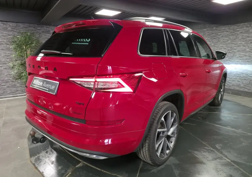 Vue 3/4 arrière droite du Skoda Kodiaq rouge avec jantes alliage 20 pouces et crochet d'attelage escamotable.