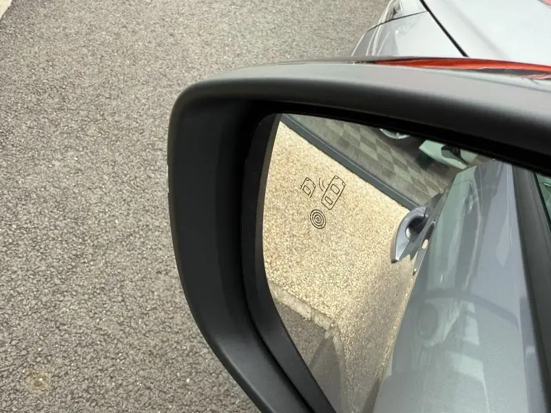 Rétroviseur droit d’une Opel Corsa 1.2 Turbo 2023 gris, avec affichage d’alerte d’angle mort visible dans le miroir.