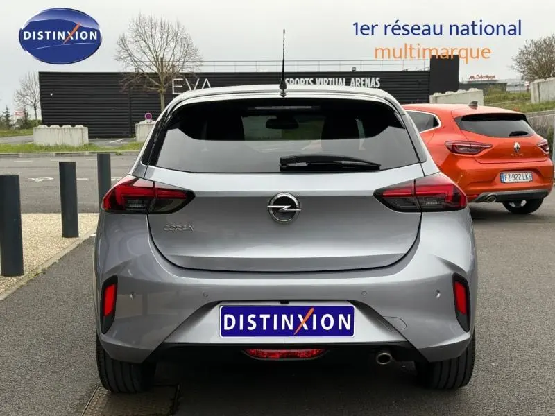 Vue arrière d'une Opel Corsa grise 2023 avec feux LED et becquet, stationnée sur un parking extérieur.
