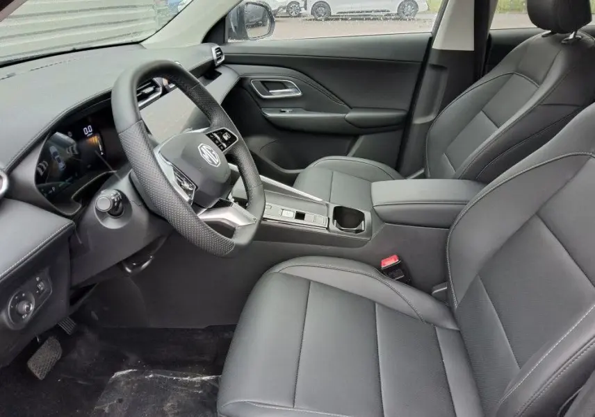 Vue intérieure côté conducteur du MG ZS 1.5 Hybrid+ 197 Luxury avec sièges cuir noirs et tableau de bord moderne.