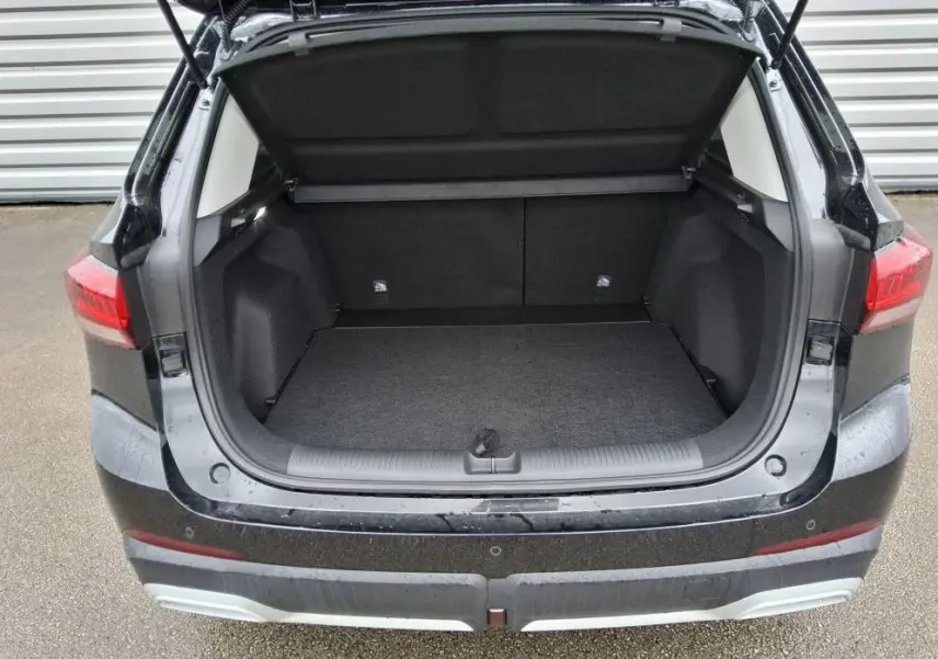 Coffre ouvert en vue arrière d’un MG ZS 1.5 Hybrid+ 197 Luxury Pebble Black avec hayon et feux arrière visibles.