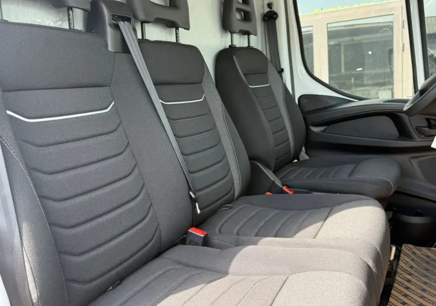 Vue intérieure côté droit montrant les sièges avant noirs du fourgon Iveco Daily 35S18 2026.