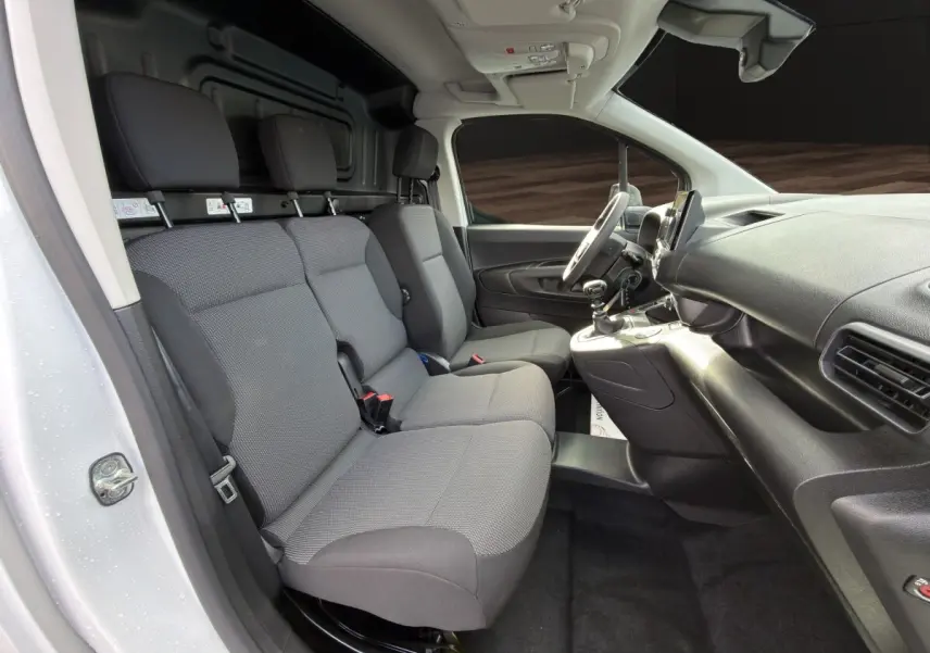 Vue intérieure côté conducteur du Citroën Berlingo blanc 2026 avec banquette 3 places et tableau de bord noir.