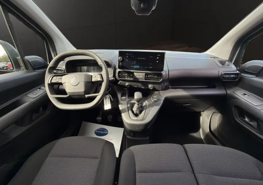 Vue intérieure avant du Citroën Berlingo blanc 2026, tableau de bord moderne avec écran tactile central et volant multifonctions.