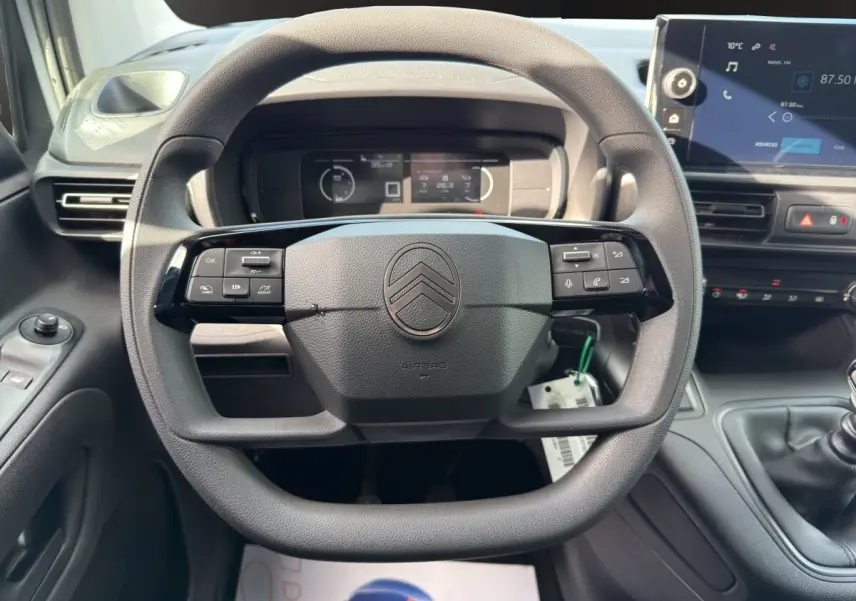 Vue intérieure centrée sur le volant multifonctions noir du Citroën Berlingo 2026 avec tableau de bord et écran tactile.