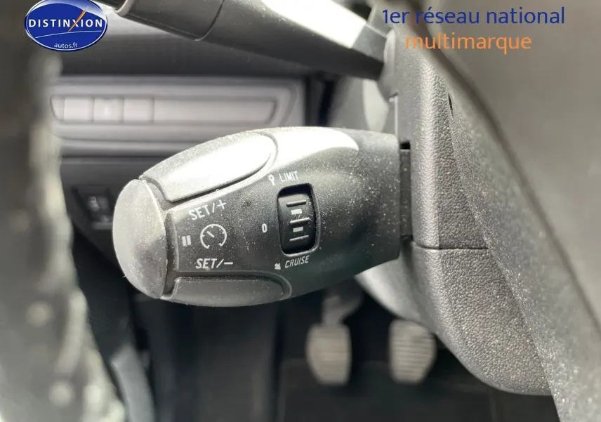 Gros plan sur la commande de régulateur de vitesse du Peugeot 2008 noir métal, côté gauche du volant.