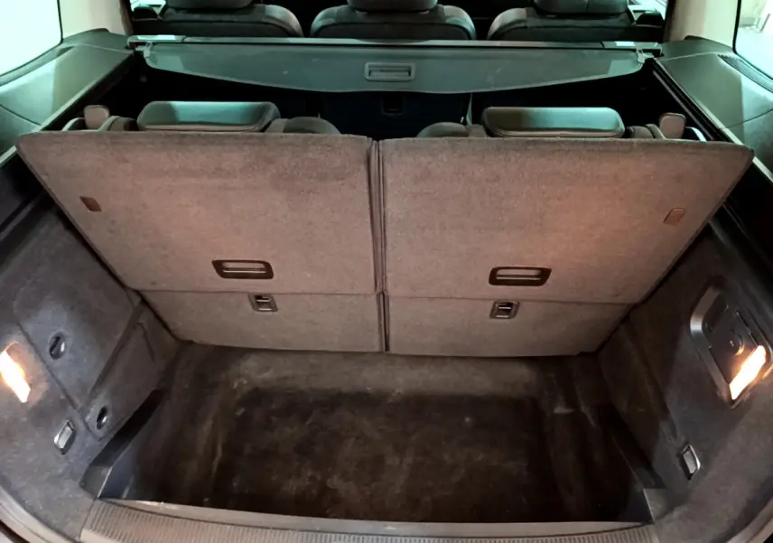 Vue intérieure du coffre arrière du Volkswagen Sharan marron 2017 avec sièges arrière relevés et plancher plat.