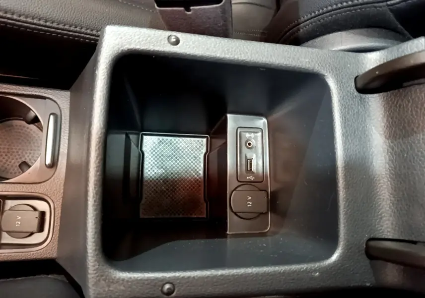 Vue rapprochée de la console centrale intérieure noire du Volkswagen Sharan 2017 avec prises USB, jack et 12V.